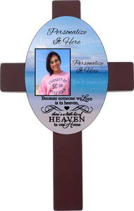 Personalized oval cross with a photo and your own words. Cross has a memorial saying because someone we love is in heaven, there is a little bit of heaven in our home. Cross has a beach background.